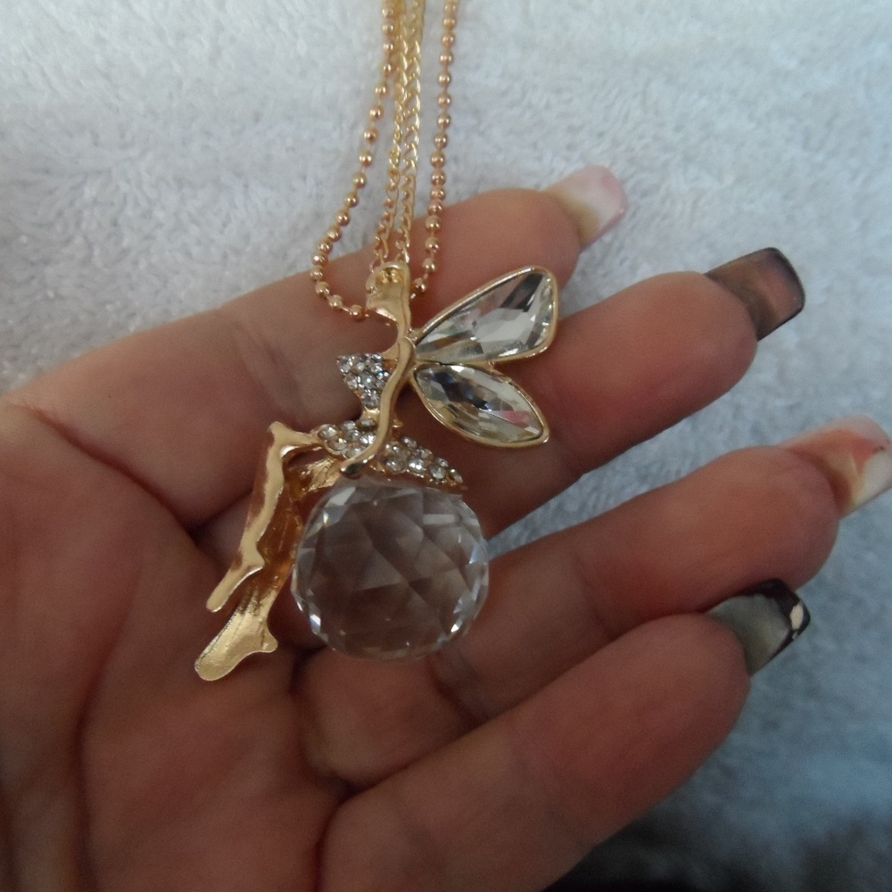 Gold tone fairy sitting on a crystal ball pendant